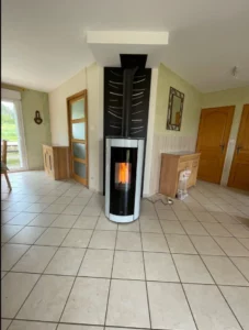 Poele mixte cylindrique blanc et noir avec habillage mural noir decore dans un sejour carrele